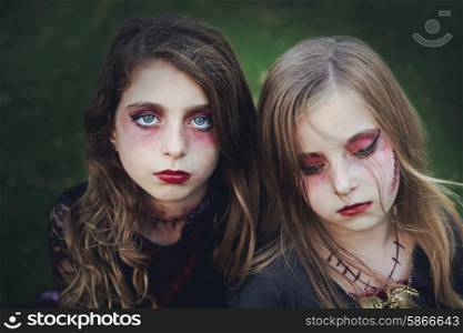 Halloween makeup kid sister girls blue eyes in outdoor backyard lawn