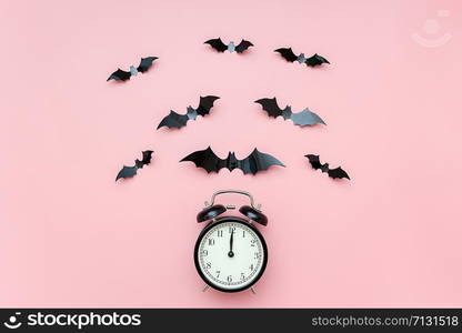 Halloween night concept. Black alarm clock and flying bats on pink background. Creative flat lay, top view, template for yuor design, greeting card, invitation.. Halloween night concept. Black alarm clock and flying bats on pink background. Creative flat lay, top view, template for yuor design, greeting card, invitation