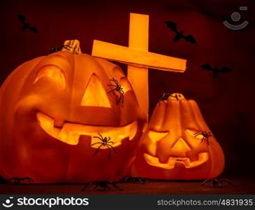 Halloween on cemetery, glowing scary gourd and creepy cross, flying bats, mysterious night, autumn seasonal holiday of horror