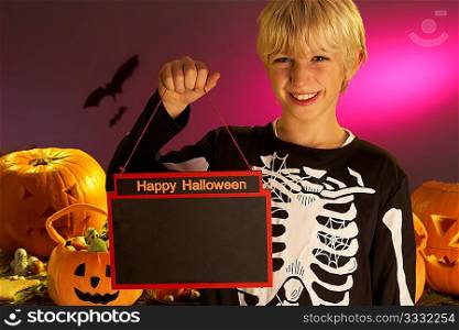 Halloween party with a boy child holding sign