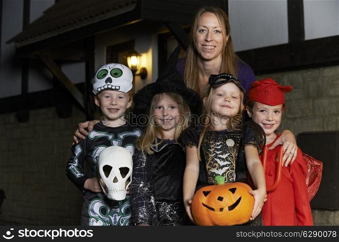 Halloween Party With Children Trick Or Treating In Costume With Mother