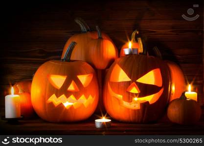 Halloween pumpkin and candles. Halloween pumpkin head jack lantern and candles on wooden background
