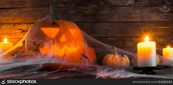 Halloween pumpkin and spiders. Jack O Lantern Halloween pumpkin, spiders on web and burning candles