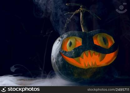 Halloween Pumpkin glowing from inside with mystery foggy smoke on wooden table still life with copy space