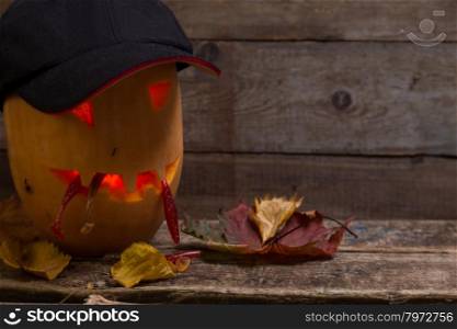 halloween pumpkin head in heat and eyeglass with fishing tackles on wooden boards background