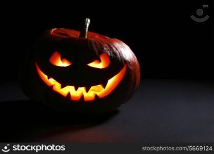 Halloween pumpkin head jack lantern with scary evil face on black