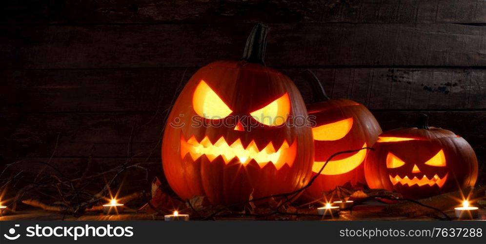 Halloween pumpkin head lantern and burning candles holiday celebration. Halloween pumpkin lantern