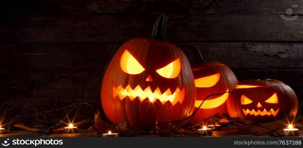 Halloween pumpkin head lantern and burning candles holiday celebration. Halloween pumpkin lantern