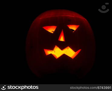 Halloween pumpkin lit by candles. Halloween pumpkin on black background lit by candles