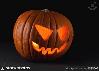 Halloween pumpkin on black. Funny glowing Halloween pumpkin isolated on a black background