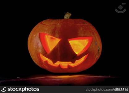 Halloween pumpkin on black. Funny glowing Halloween pumpkin isolated on a black background