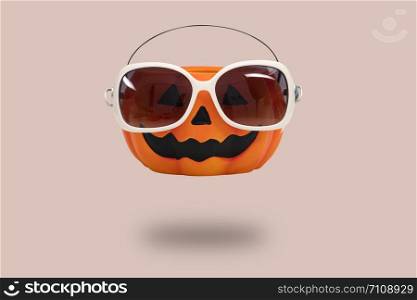 Halloween pumpkin with glasses on pink background. Halloween minimal idea concept.