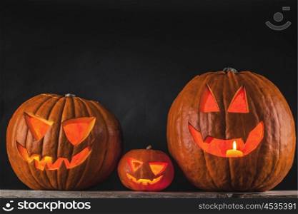 Halloween pumpkins on black. Funny glowing Halloween pumpkins on a black background