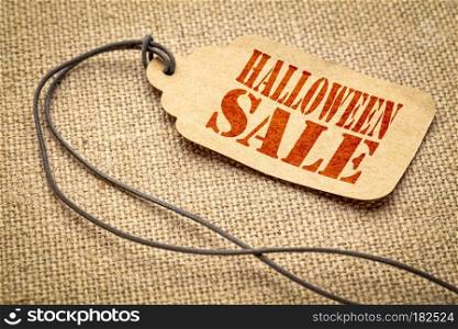 Halloween sale  - a paper price tag with a twine iagainst burlap canvas