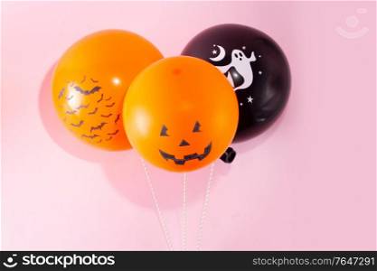 Halloween scene with orange and black balloons on pink background. Halloween scene with balloons