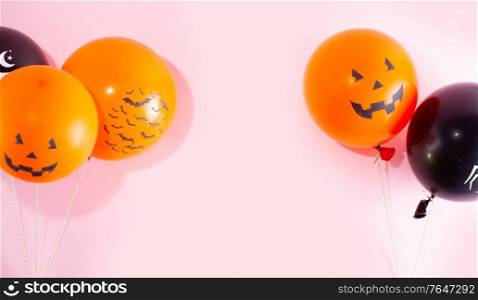 Halloween scene with orange and black balloons on pink background. Halloween scene with balloons