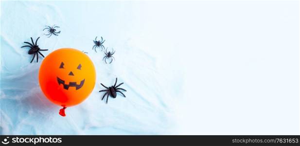 Halloween scene with scary balloon and spiders in web on blue. Halloween scene with balloons