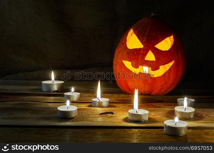Halloween symbol smiling pumpkin lantern and burning candles. Halloween symbol smiling pumpkin lantern and burning candles. Halloween jack-o-lantern and burning candles background.