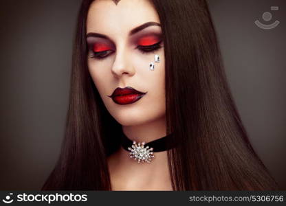 Halloween Vampire Woman portrait. Beautiful Glamour Fashion Sexy Vampire Lady with long dark Hair, beauty make up and Costume