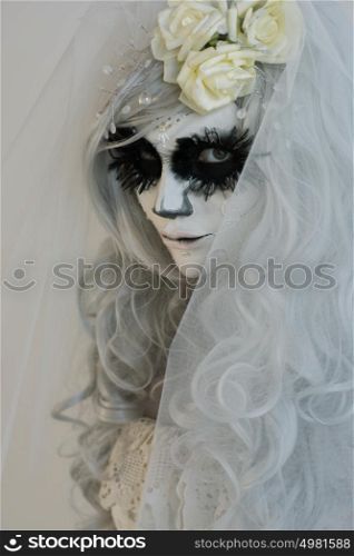 Halloween witch. Beautiful woman wearing santa muerte mask and wedding dress