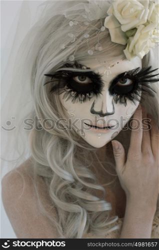 Halloween witch. Beautiful woman wearing santa muerte mask and wedding dress