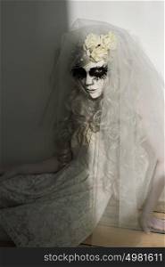 Halloween witch. Beautiful woman wearing santa muerte mask and wedding dress. Dead widow in grief