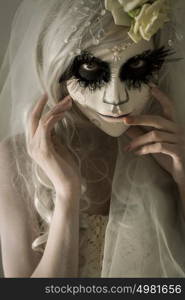 Halloween witch. Beautiful woman wearing santa muerte mask and wedding dress. Dead widow in grief