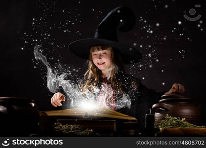 Halloween witch. Little Halloween witch making magic with stick