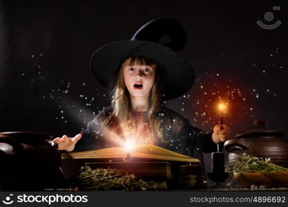 Halloween witch. Little Halloween witch making magic with stick