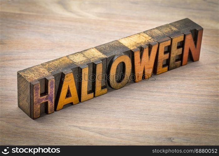 Halloween word abstract in vintage letterpress wood type against grained wood