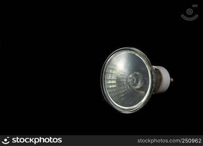 Halogen bulb of GU10 type on a black background with extensive copy space