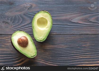 Halved avocado on the wooden background