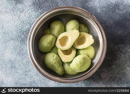 Halved avocados in the metal bowl