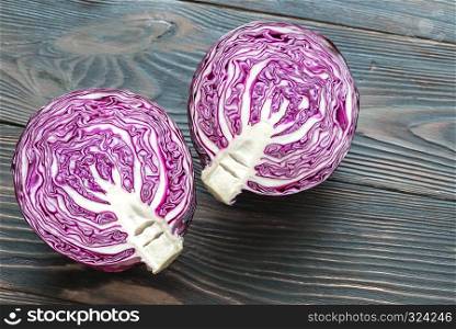 Halved red cabbage on the wooden background