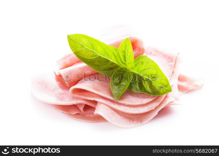 Ham slices isolated on white with green basil leaves