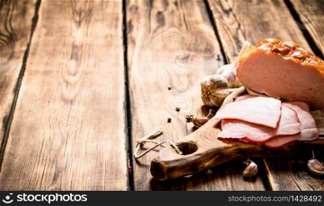 Ham with garlic and spices on the old Board. On wooden background.. Ham with garlic and spices on the old Board.