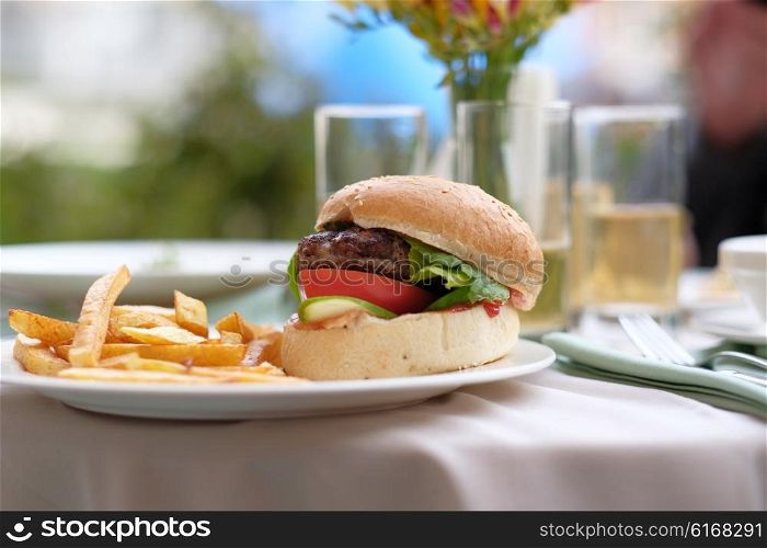 Hamburger and fries at restaurant outdoor table