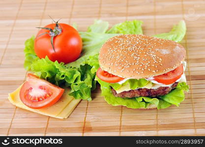 hamburger with cutlet and vegetables on bamboo napkin