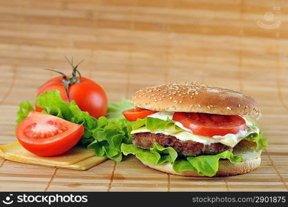 hamburger with cutlet and vegetables on bamboo napkin