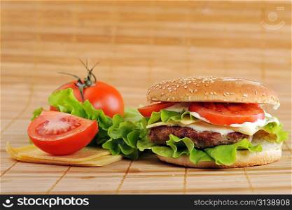hamburger with cutlet and vegetables on bamboo napkin