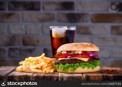 Hamburger with french fries and cola on wooden table