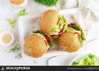 Hamburger with grilled chicken burger, fresh cucumber, tomato, cheese and lettuce. Top view.
