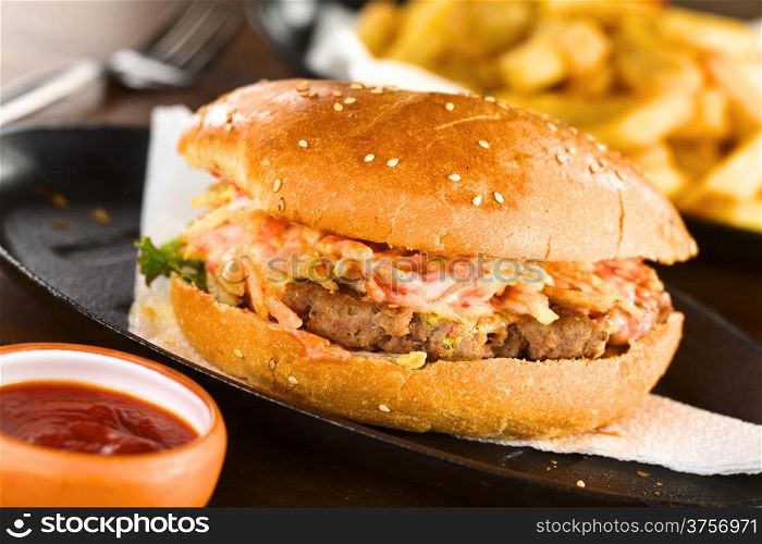 Hamburger with ketchup and French fries (Selective Focus, Focus on the front of the hamburger)