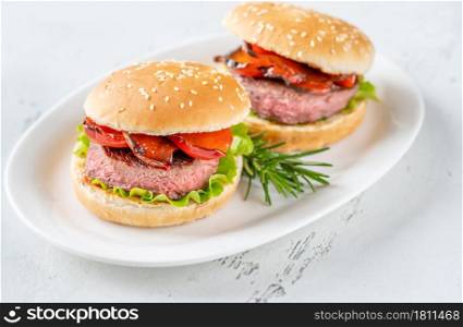 Hamburgers with grilled pepper on the white serving plate