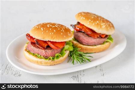Hamburgers with grilled pepper on the white serving plate