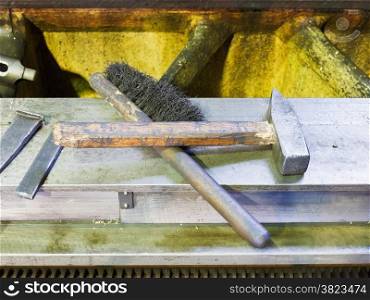 hammer and metal brush on lathe machine frame