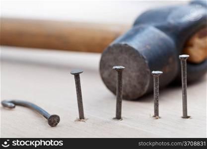 hammer and nails into wooden board close up