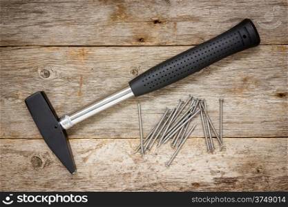 Hammer and nails on the wooden background