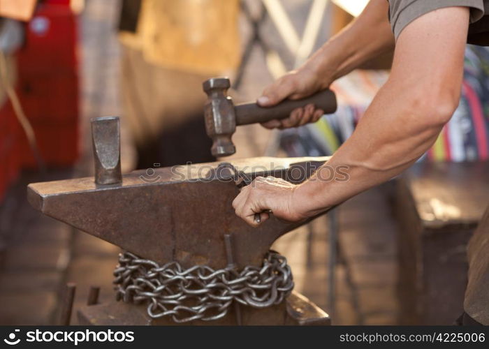 hammer, anvil and the hands of a blacksmith