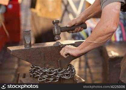 hammer, anvil and the hands of a blacksmith